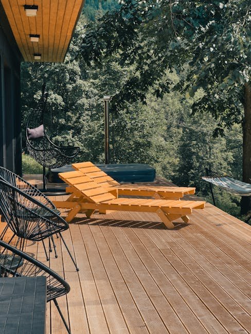 Wooden deck with lounge chairs surrounded by lush greenery, perfect for relaxation.