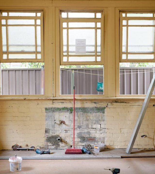 An empty room featuring large windows, ready for renovation in Sydney, Australia.